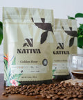 Nativa coffee packages with coffee beans and a glass of coffee on a wooden surface.