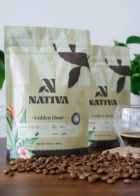Nativa coffee packages with coffee beans and a glass of coffee on a wooden surface.