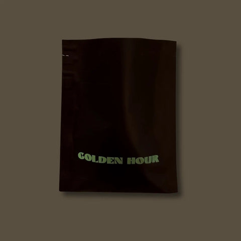 Sample Black bag of coffee titled 'GOLDEN HOUR' on a dark background