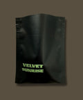 Black pouch with 'Velvet Sunrise Coffee' text on a brown background